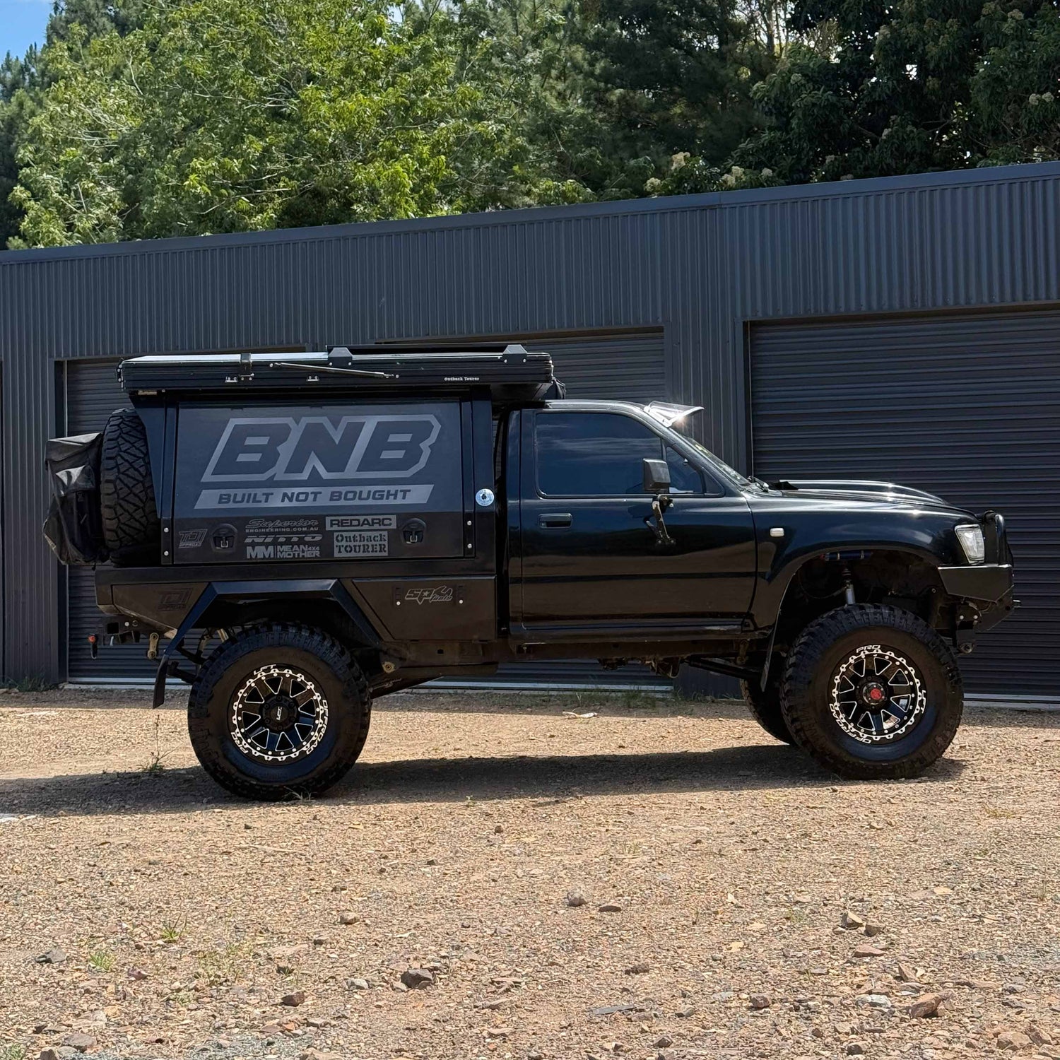 1006 Toyota LN106 Hilux with R1-REBEL LFT Wheels side angle 4x4 17x9 -12mm offset Black paint